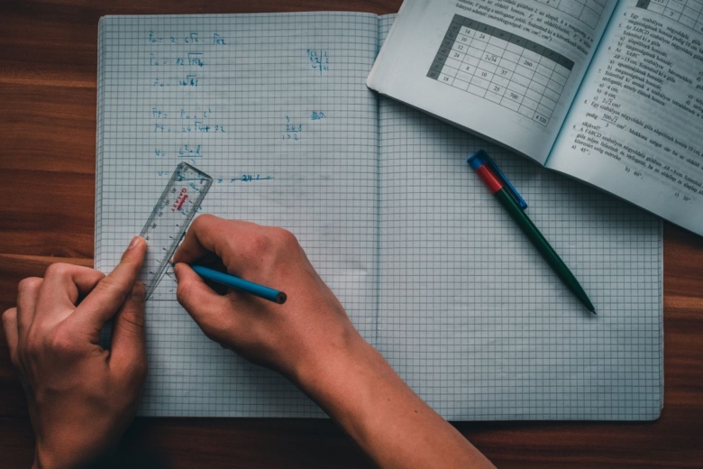 Élève écrivant ses exercices de maths dans un cahier